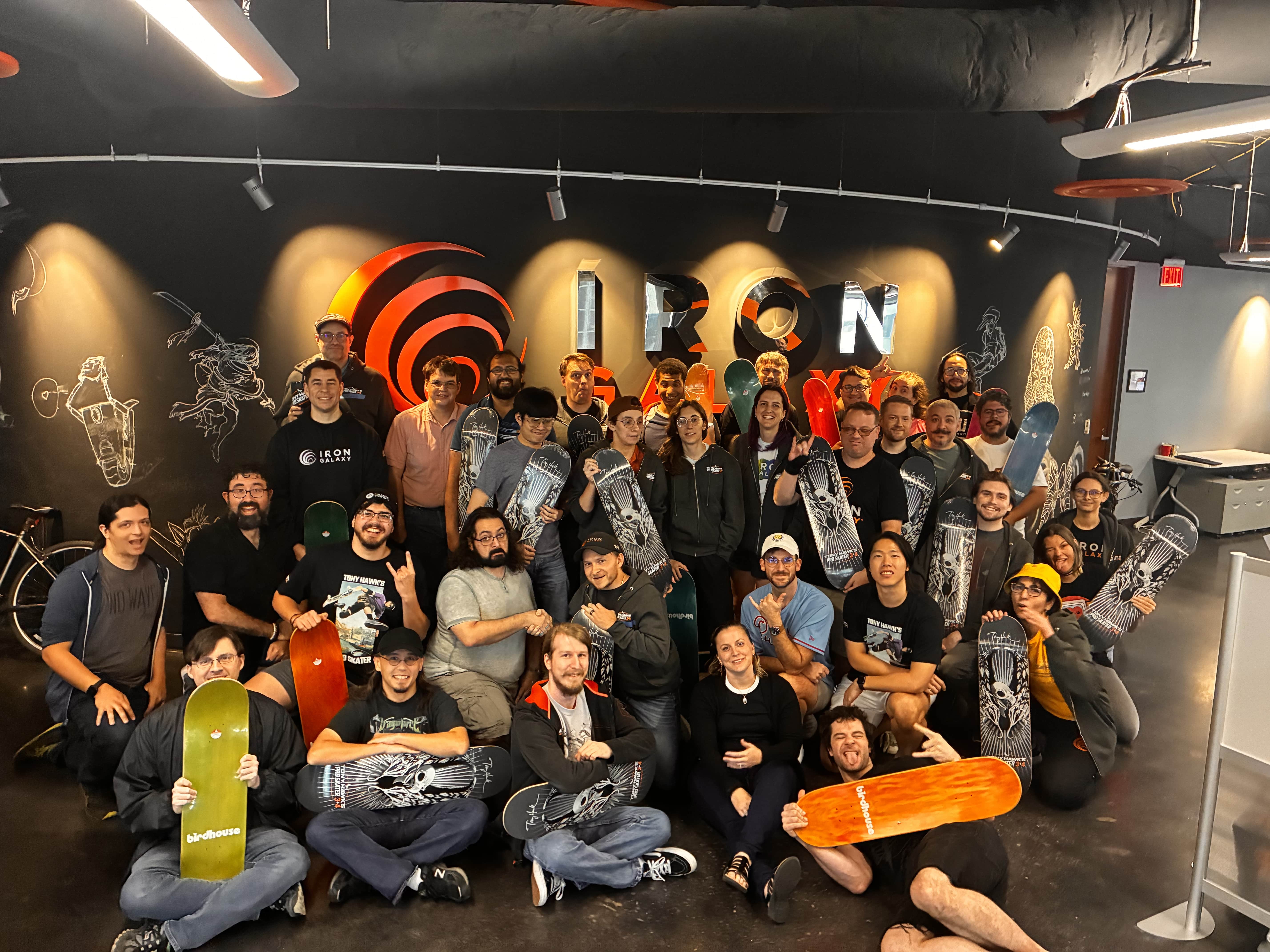 Iron Galaxy’s Orlando team holding skateboards at the Tony Hawk’s Pro Skater 3 + 4 launch celebration