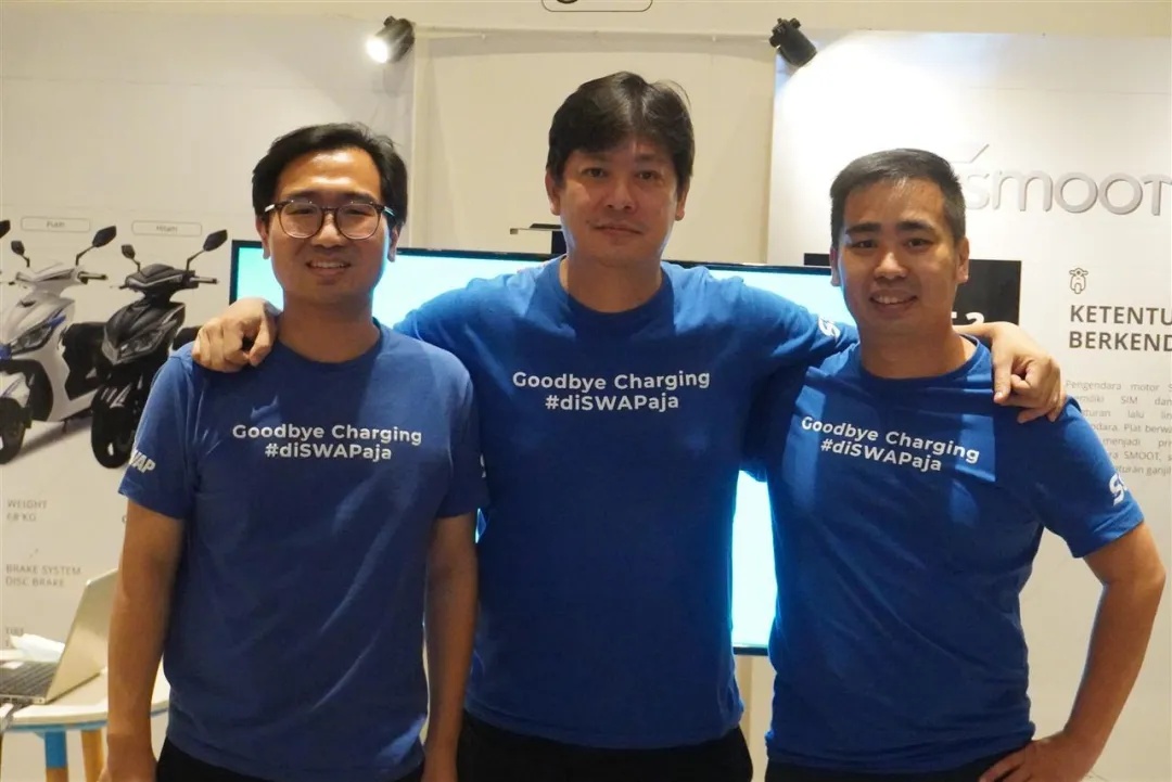 Irwan Tjahaja, centre, with two colleagues in matching blue Swap and Smoot T-shirts
