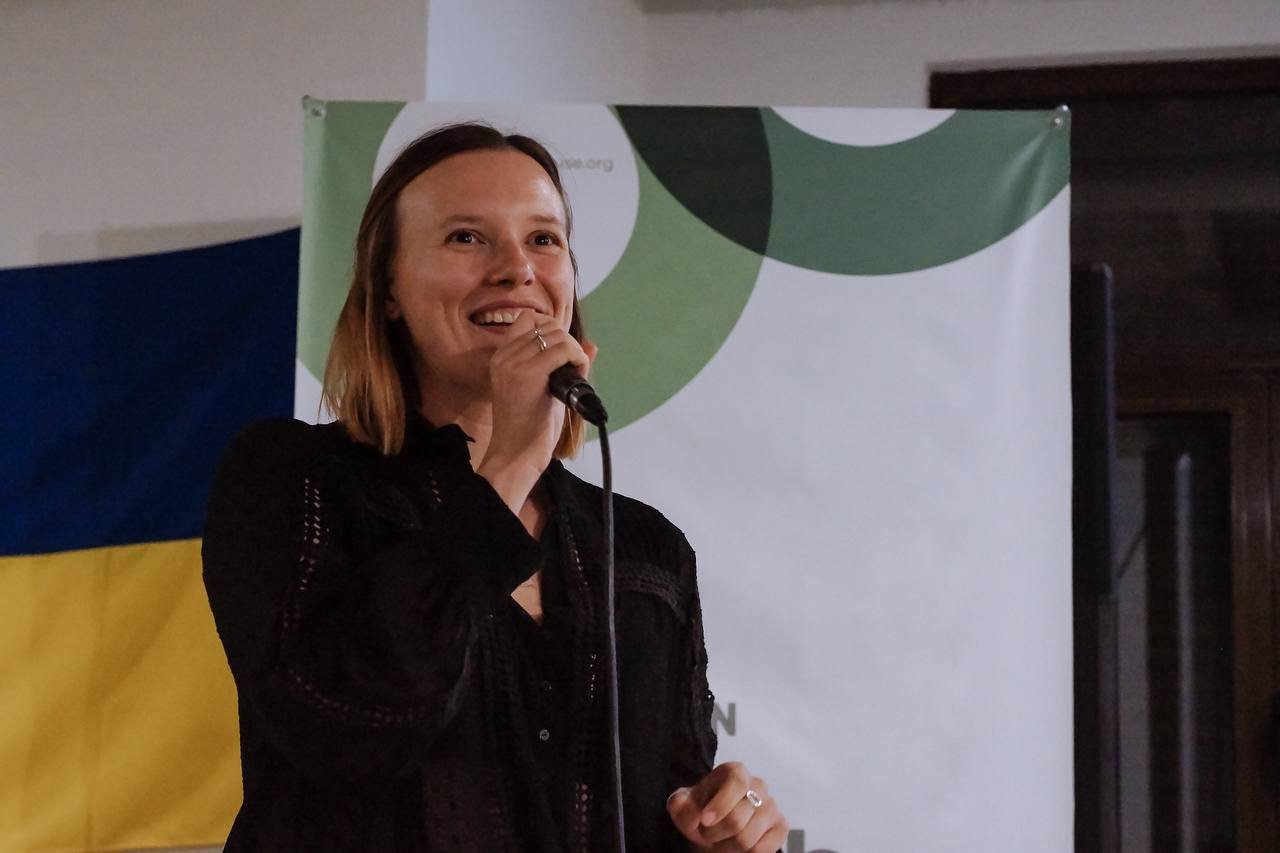 Iryna Shostak speaking into a microphone at the Creative Communications Academy