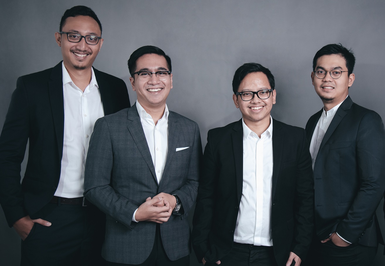 Kata.ai’s four founding team members standing together in suits in 2017