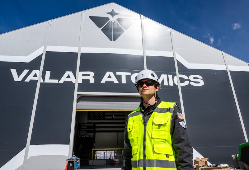 Isaiah Taylor wearing a hard hat and high-visibility vest at Valar Atomics' Utah facility