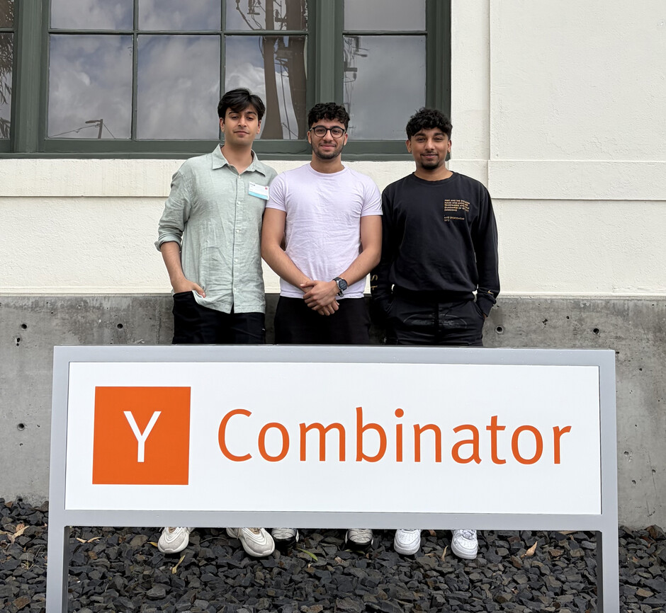Hexa co-founders Auri Nayak, Ishaan Makkar and Mann Patira standing behind a Y Combinator sign