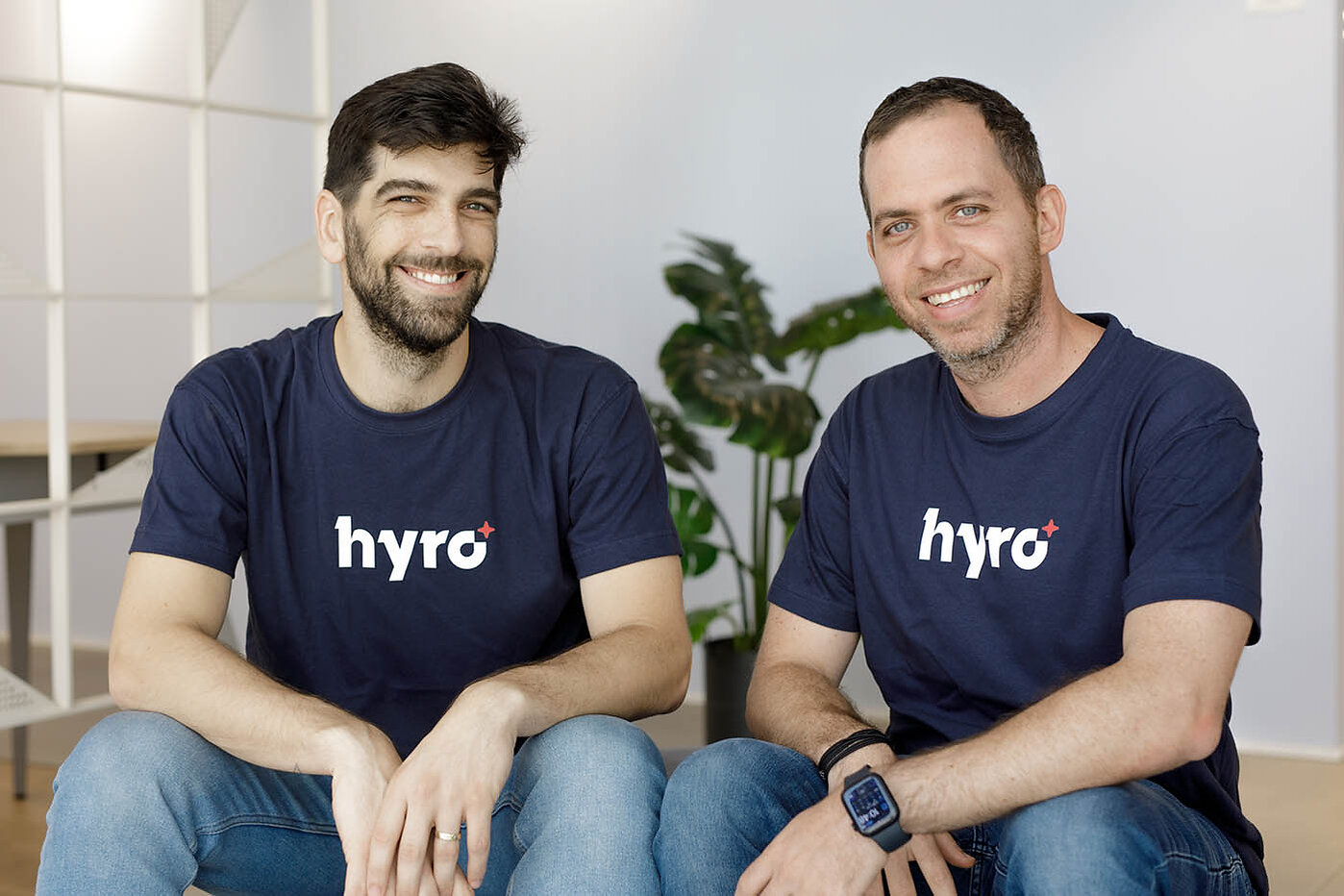 Hyro co-founders Rom Cohen on the left and Israel Krush on the right, seated in matching navy Hyro shirts