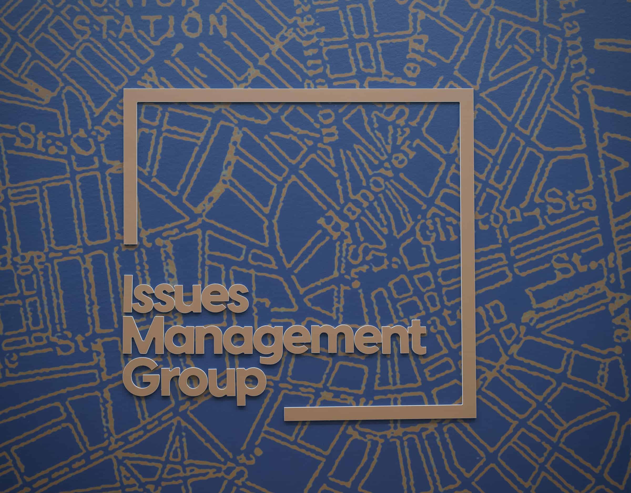Issues Management Group office wall in Boston with the company's name over a map pattern