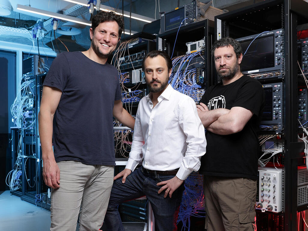 Yonatan Cohen, Itamar Sivan and Nissim Ofek standing beside racks of laboratory electronics