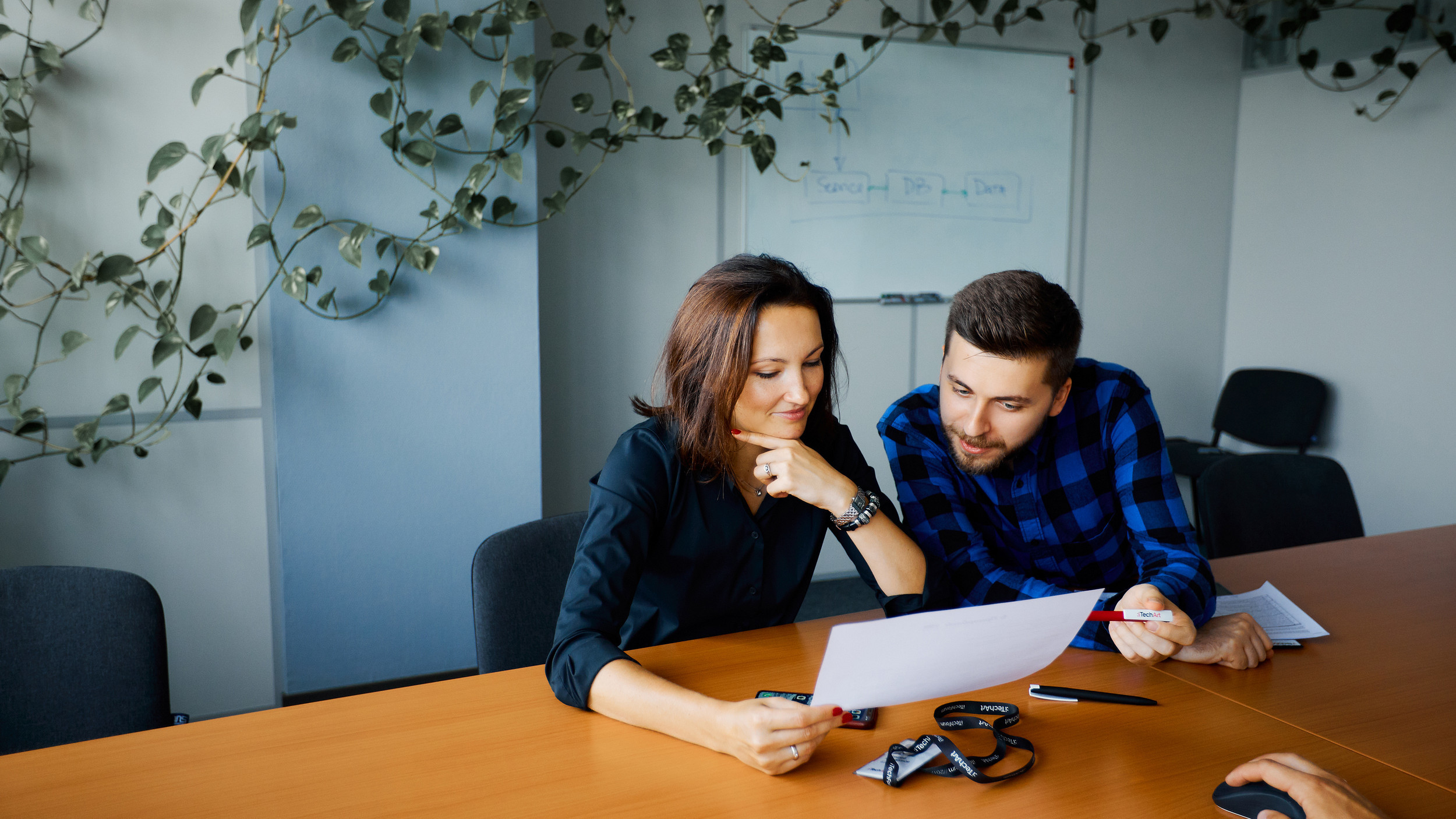 Two iTechArt colleagues review documents together at an office table