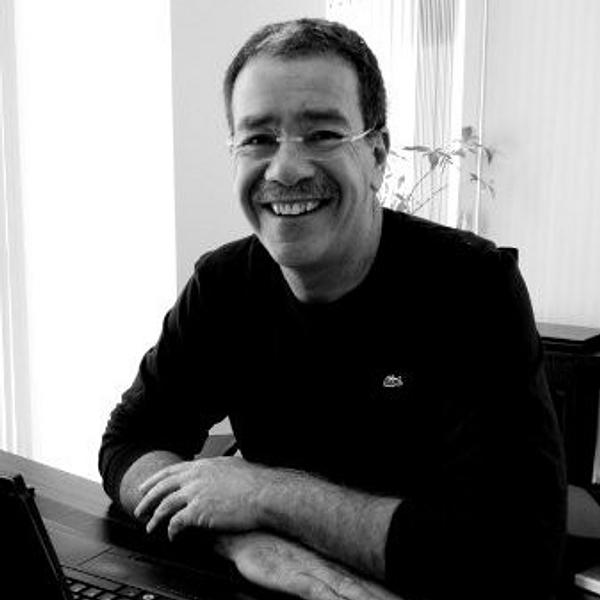 Itschak Friedman smiling at a desk, with a laptop in front of him