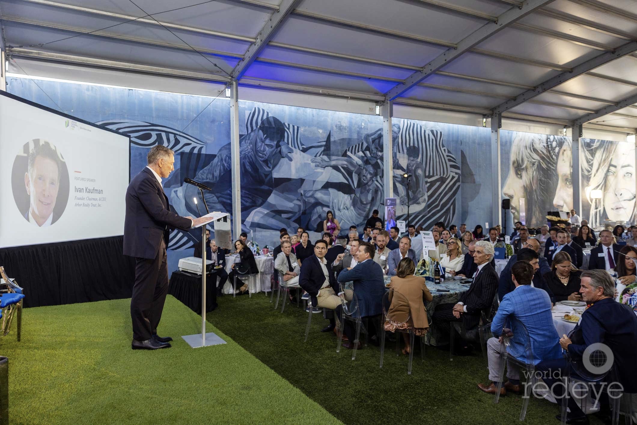 Ivan Kaufman speaking at a lectern to guests at the Jewish National Fund-USA real estate reception in Miami