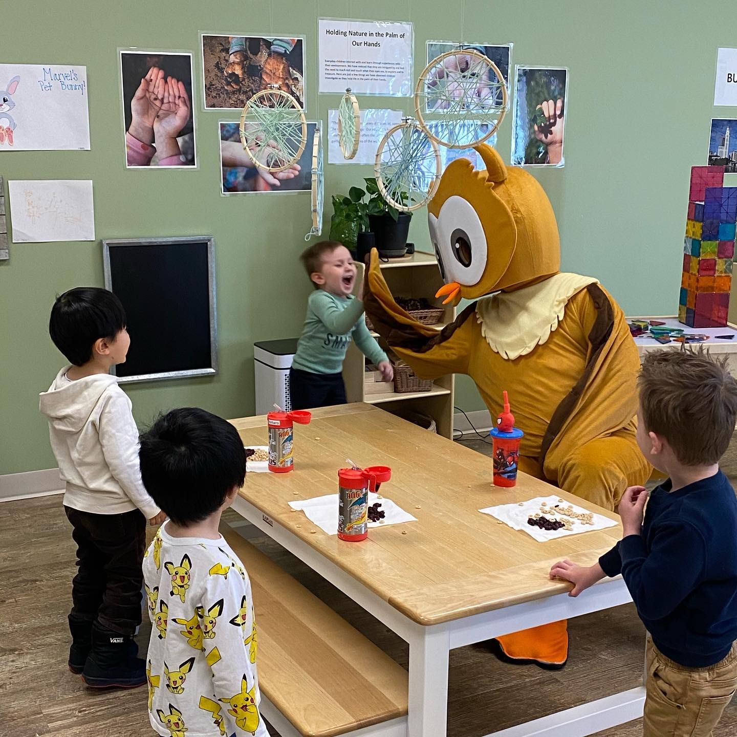 Children greeting the Ivybrook Academy owl mascot in a classroom