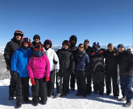 J2 colleagues gathered together in ski clothing on a snowy mountain