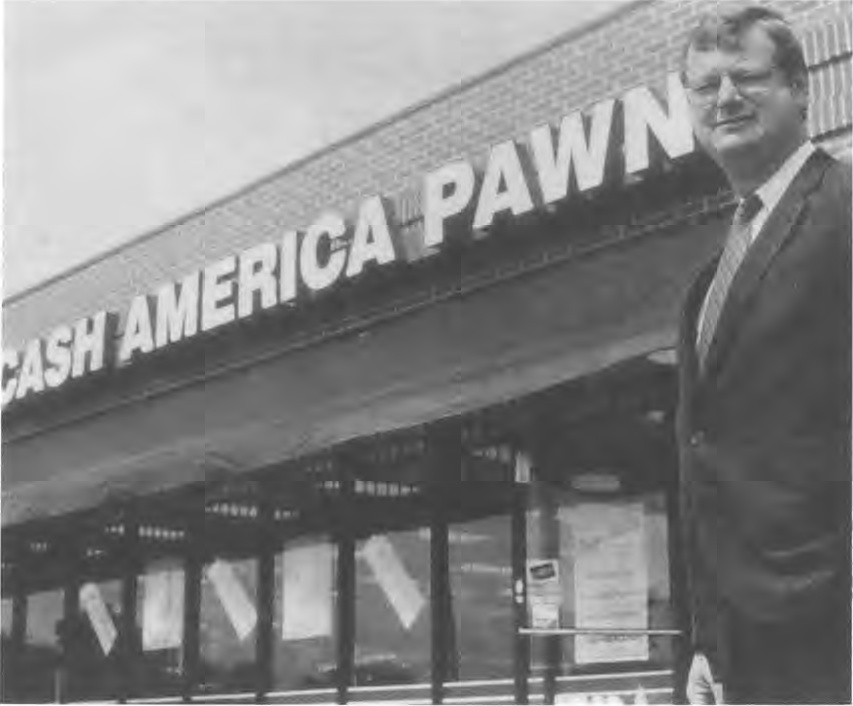 Jack Daugherty standing outside a Cash America Pawn store in an archival black-and-white photograph.