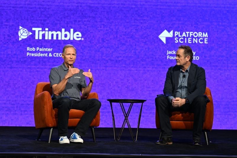 Trimble CEO Rob Painter, left, and Jack Kennedy, right, seated on a conference stage.