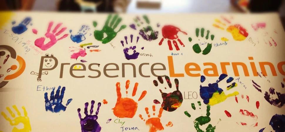A PresenceLearning sign covered with colorful painted handprints