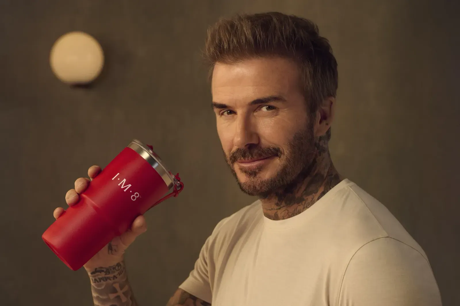 David Beckham holding an IM8 wellness product