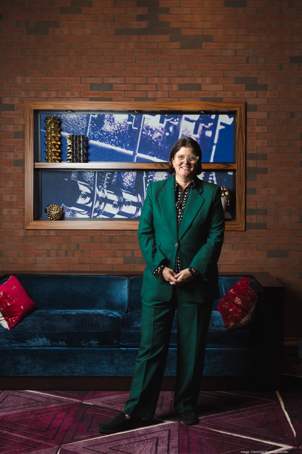 Jackie Reau standing in a green suit in a colorful interior