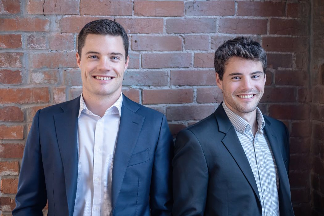 Jackson Fregeau on the left and his brother Jamieson on the right, standing beside a brick wall