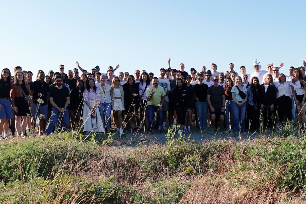 Quandri team members gathered outdoors beside the water