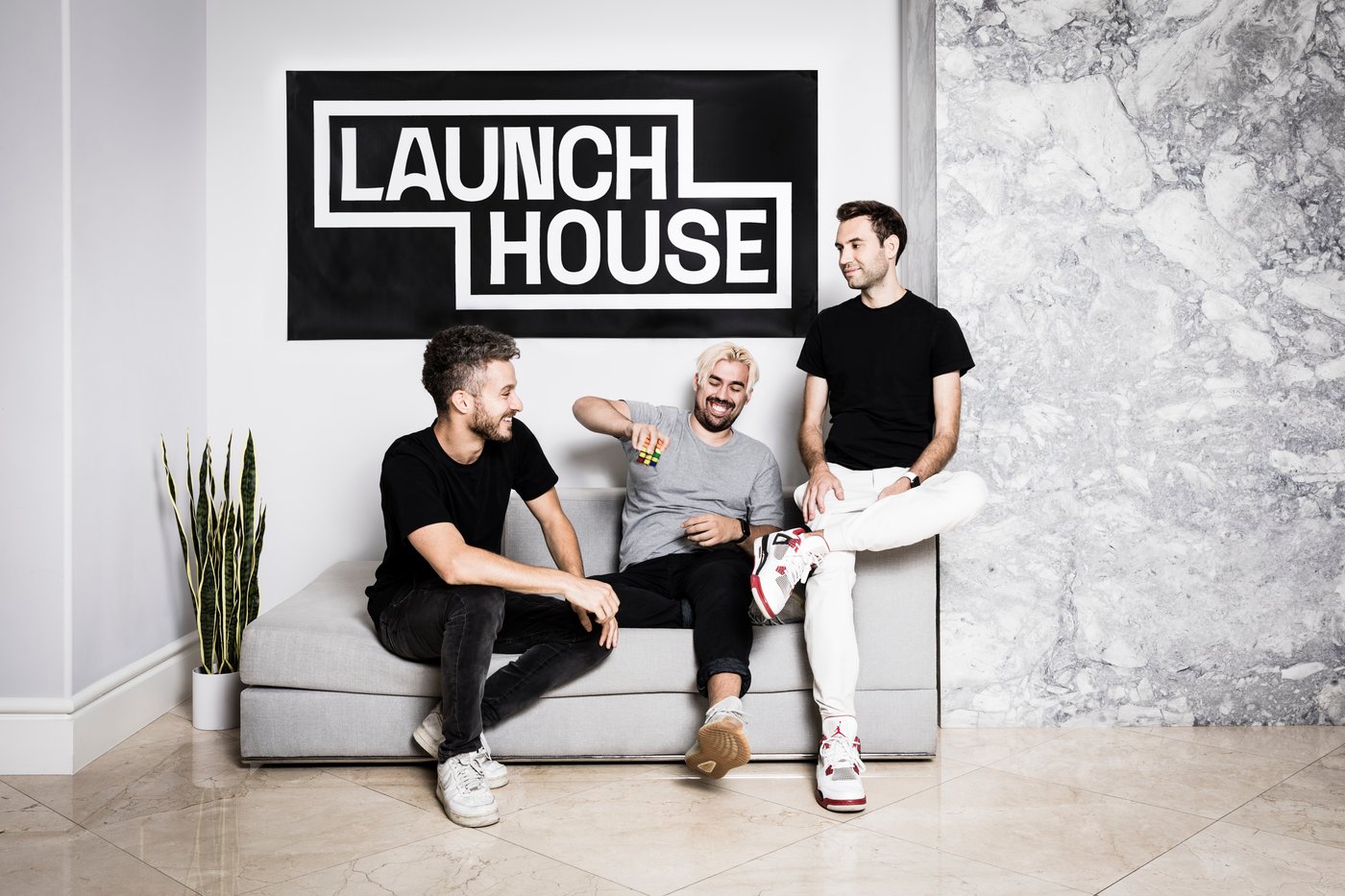 Launch House co-founders Brett Goldstein, Michael Houck and Jacob Peters seated together on a sofa
