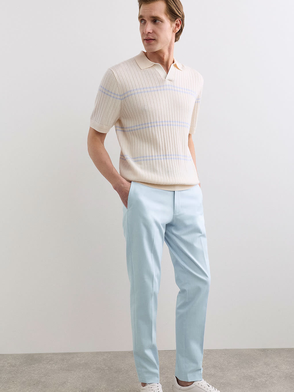 Jaeger 2026 menswear: a striped short-sleeve knit polo with pale blue trousers.