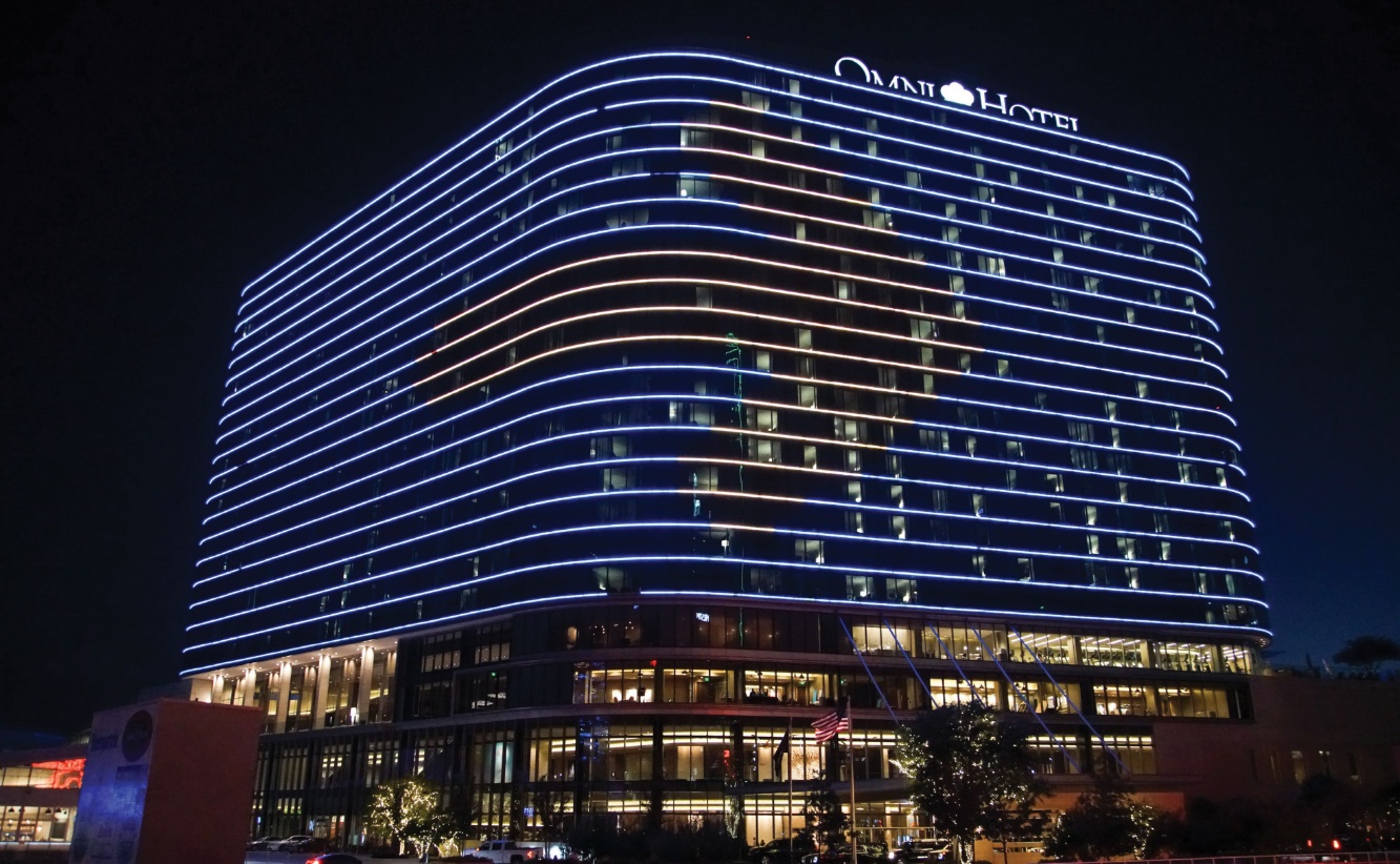 An Omni hotel at night, its exterior traced in bright lines, from Jaguar Design Studio’s live-event portfolio