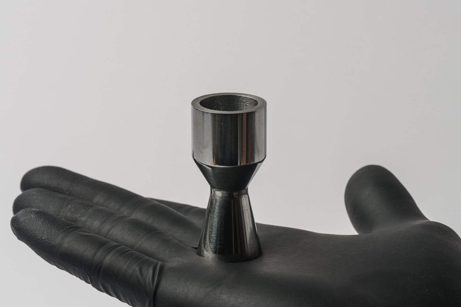 A gloved hand holding a metal component made by Foundation Alloy