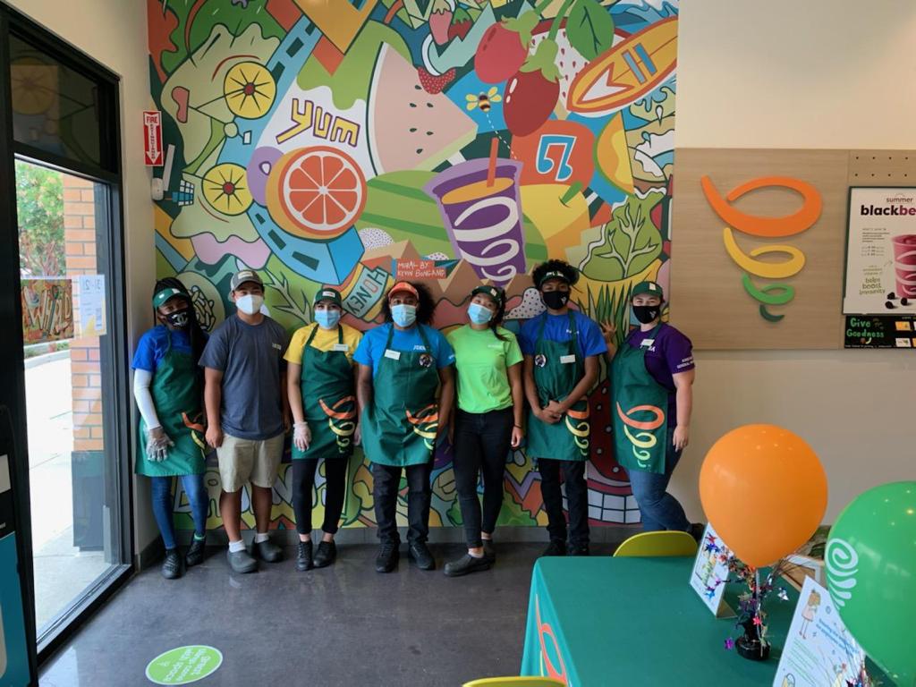 Alameda Jamba team wearing aprons and masks beneath a colorful fruit mural in 2020