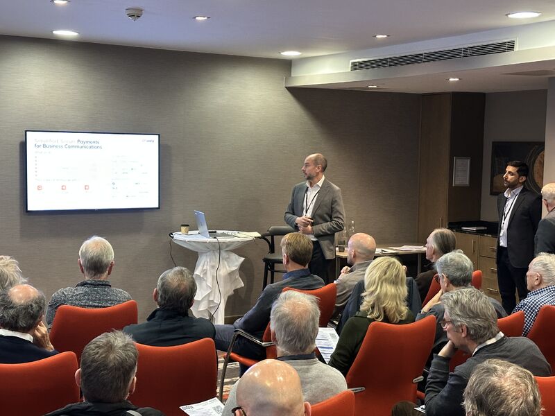 James Barham presenting to seated investors at Mello Events, with CTO Mufti Monim standing beside him.