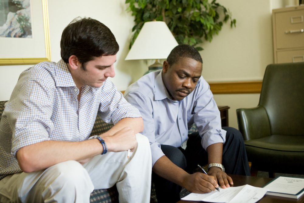 A young James Beshara sits with Wake Forest economics professor Sylvain Boko as they review documents for a student development fund.