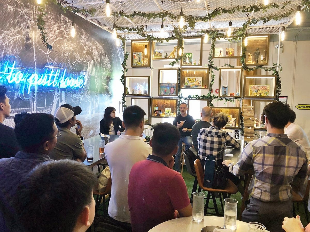 James Chia seated at the front of a gathering, speaking to SUSS entrepreneur-alumni