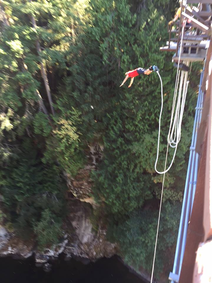 James DeGreef bungee jumping above a wooded gorge