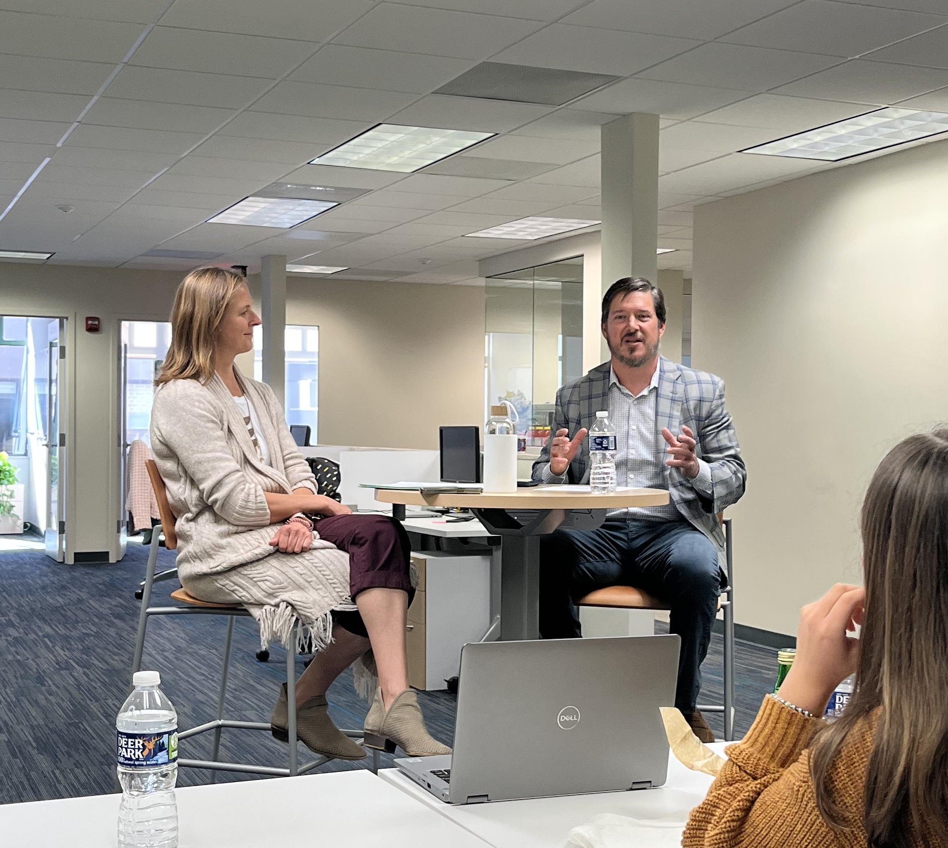 Jim Scott, at right in a checked jacket, talks with Nancy Belmont during an Applied Policy retreat