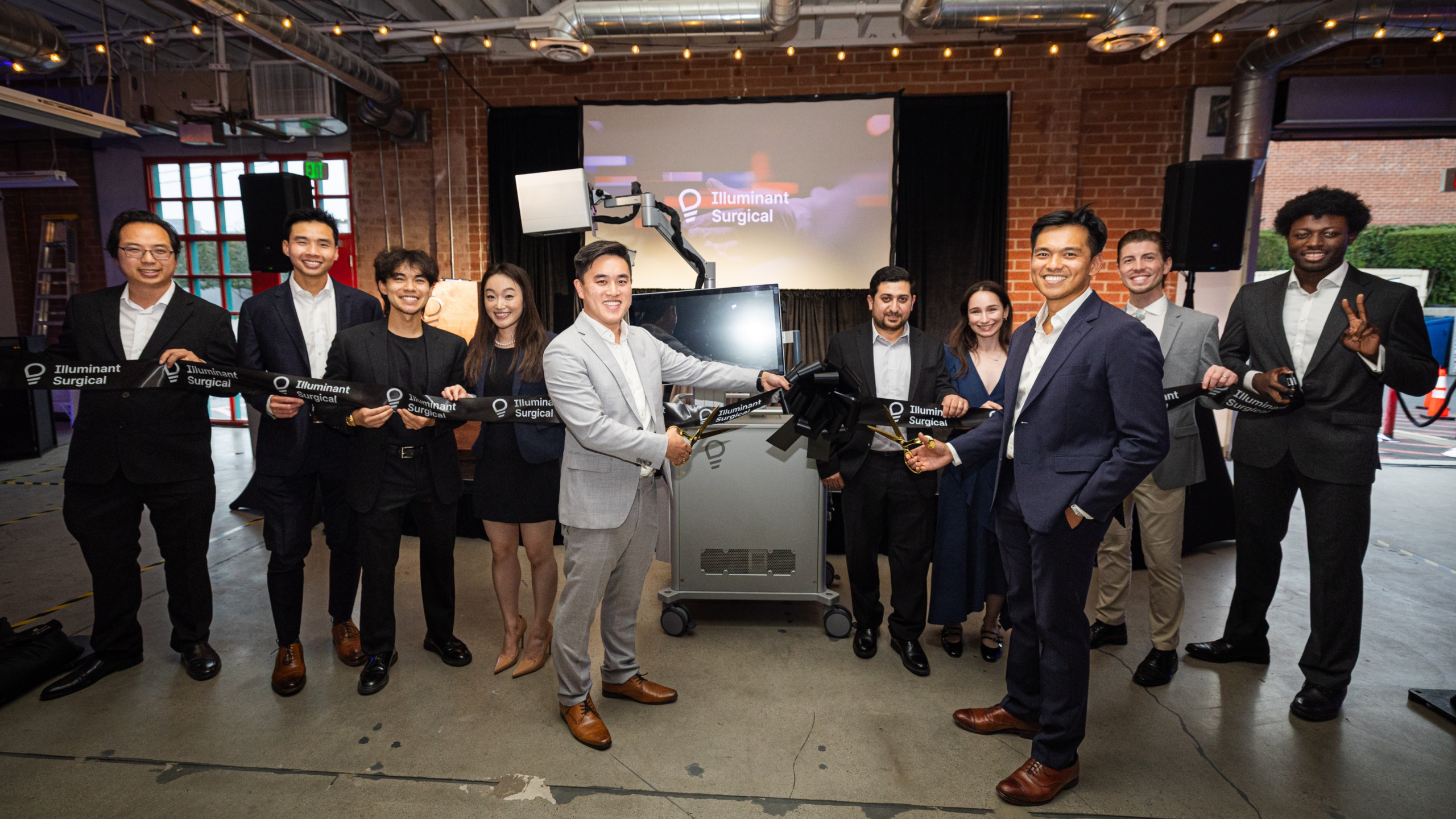 James Hu in a light suit joins Eldrick Millares and colleagues for the Nexus headquarters ribbon cutting