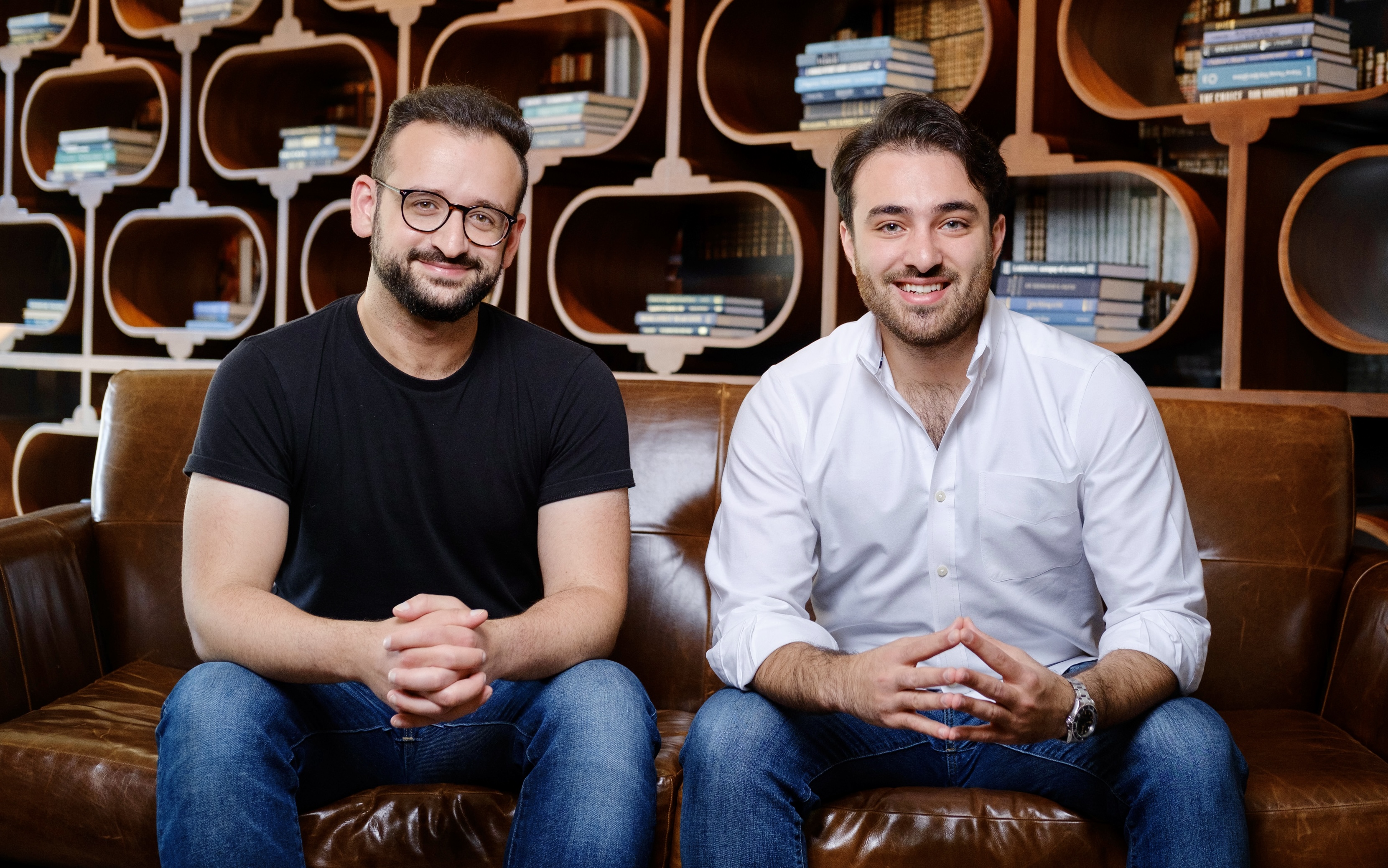 Flyp co-founders Dani Arnaout and James Kawas sitting together on a leather sofa