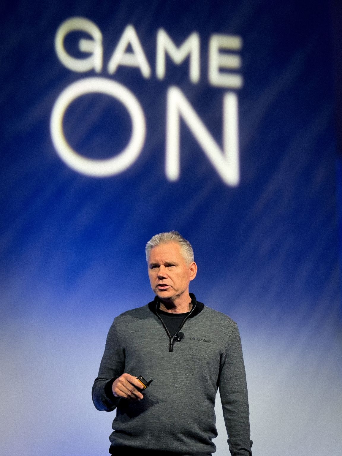 Jim Kessler speaking beneath a Game On sign at RB Global’s 2025 sales kickoff
