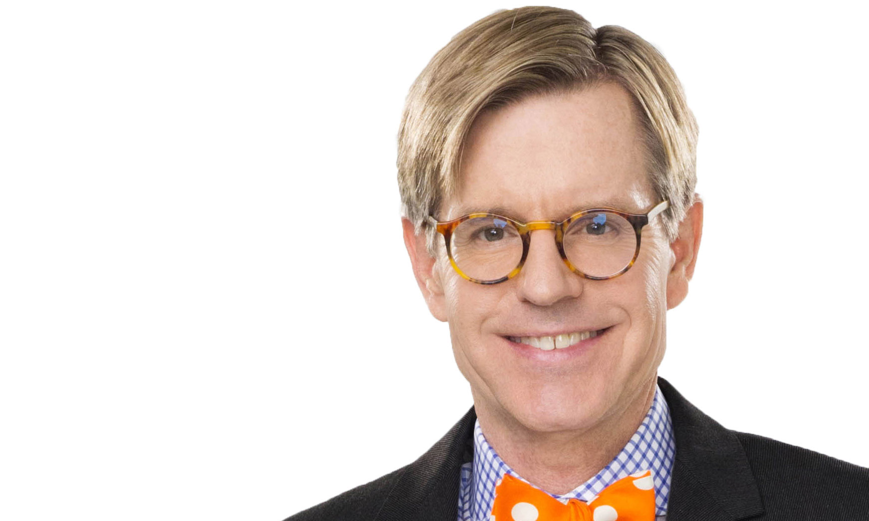 James LaForce in glasses, a checked shirt and an orange polka-dot bow tie against a white background