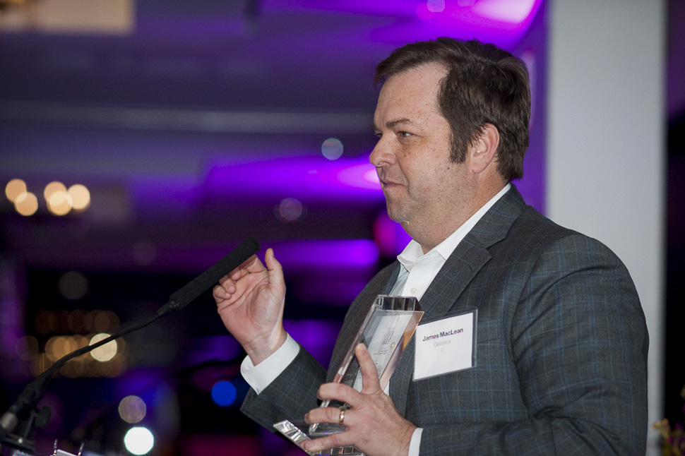 James MacLean speaking at the 2020 Innovation Awards while holding a trophy