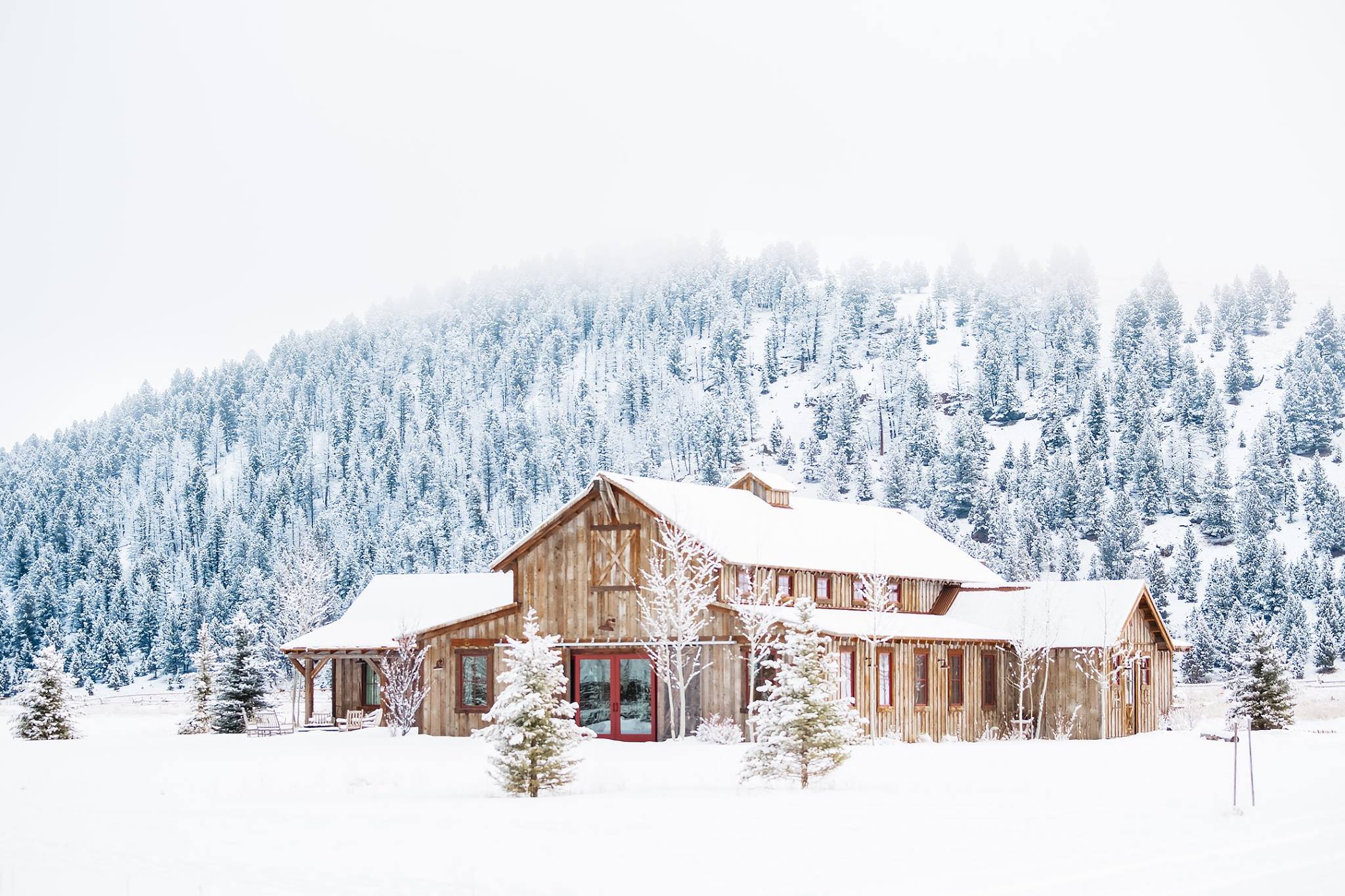 Timber ranch building surrounded by snow-covered trees at Rock Creek