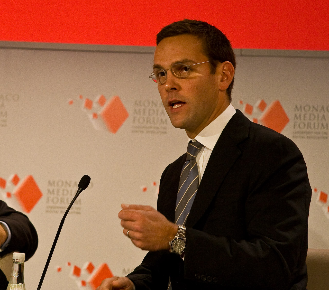 James Murdoch speaking into a microphone at the Monaco Media Forum in 2008