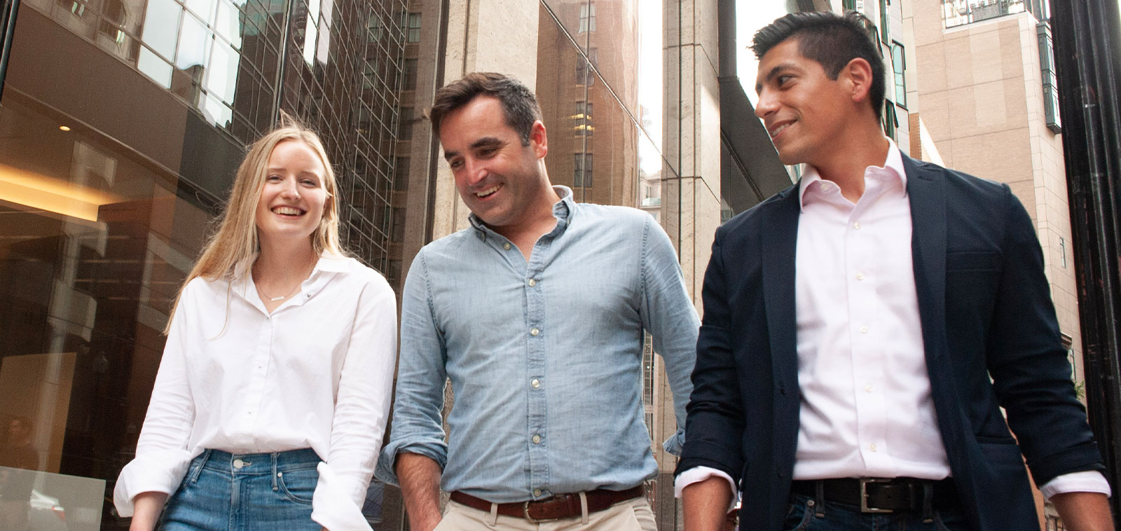 James Ward, center, smiling with two colleagues outside a building