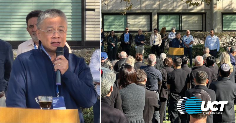 James Xiao speaks into a microphone at an outdoor UCT Fluid Solutions employee gathering in Israel.
