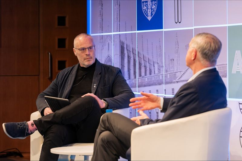Jan van de Winkel, at right, gestures during a seated conversation with Mike Rea in Cambridge.