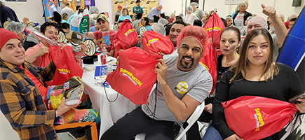 A company-provided group photograph of J&J team members holding swag bags