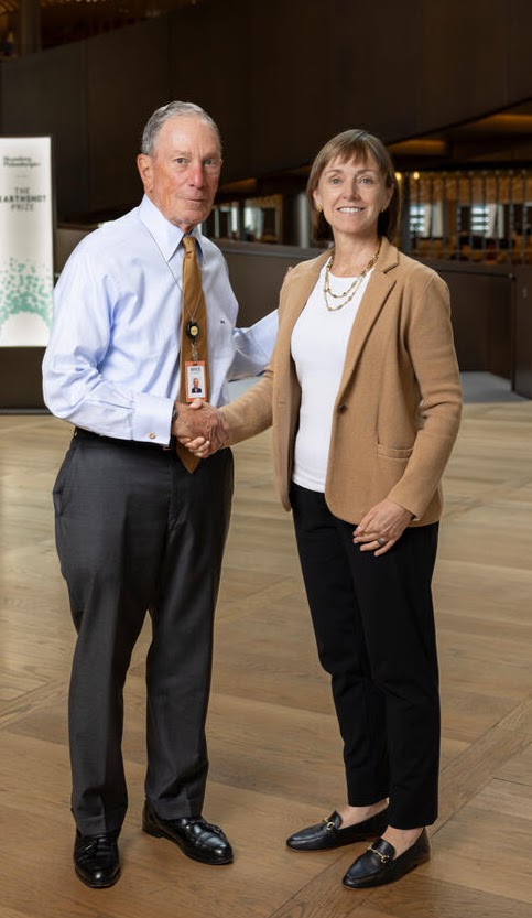 Jane Melia shaking hands with Michael Bloomberg at the 2024 Earthshot Innovation Camp