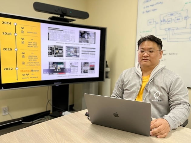 Jangwoo Kim at a laptop beside a screen showing a research timeline ending in MangoBoost