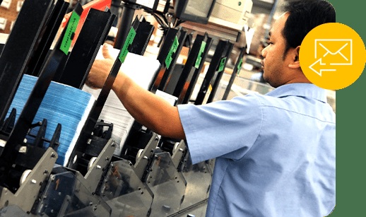 A worker handling printed direct mail on the Japs-Olson production floor