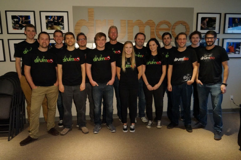 Jared Falk and colleagues in Drumeo shirts standing together at the studio