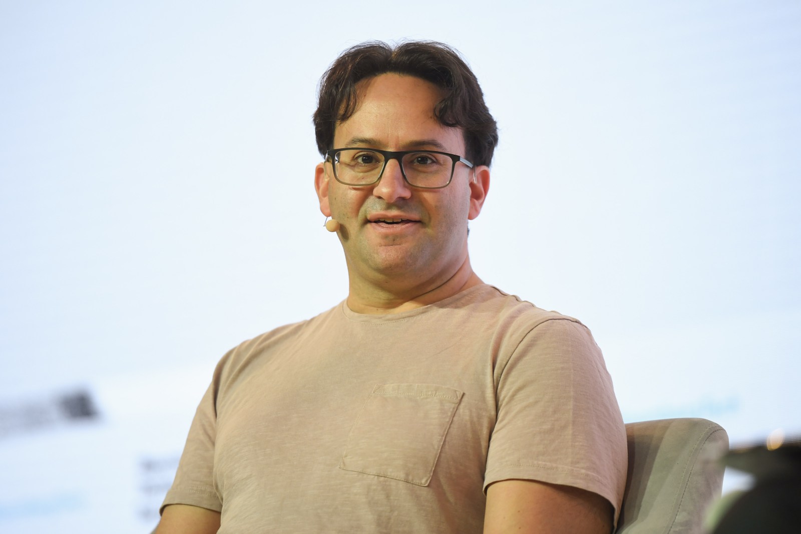 Jared Kaplan speaking onstage at a technology event