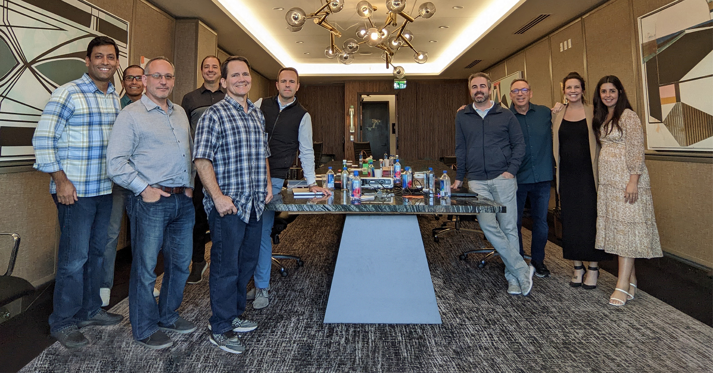 Ten members of SproutLoud’s leadership team stand around a conference table; Jared Shusterman is seventh from the left.