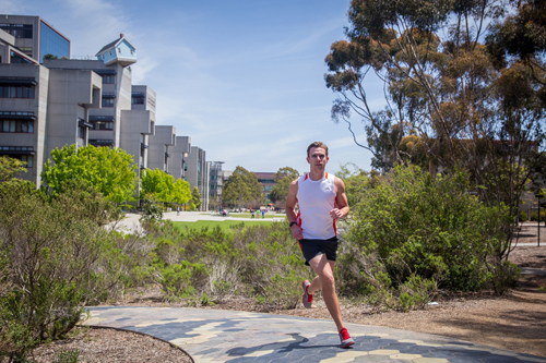 Jared Tangney running on the UC San Diego campus while testing an early wearable sensor
