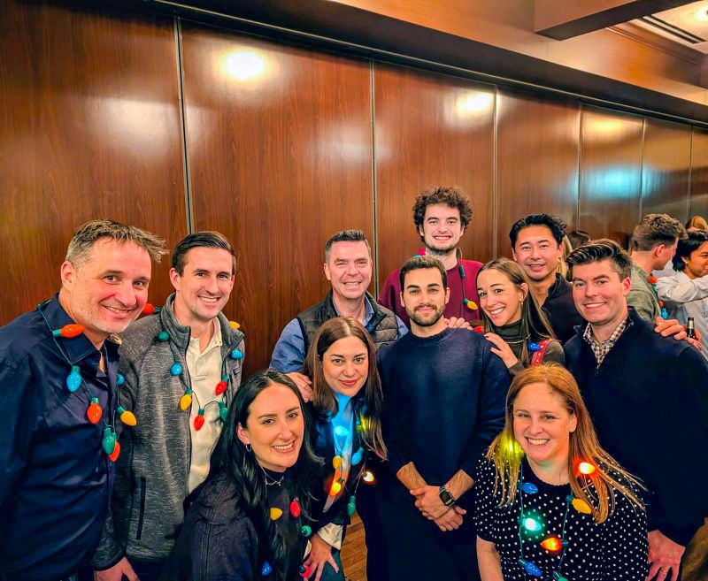 Jason Downie, at left, with colleagues at a Making Science team gathering, wearing colorful festive lights